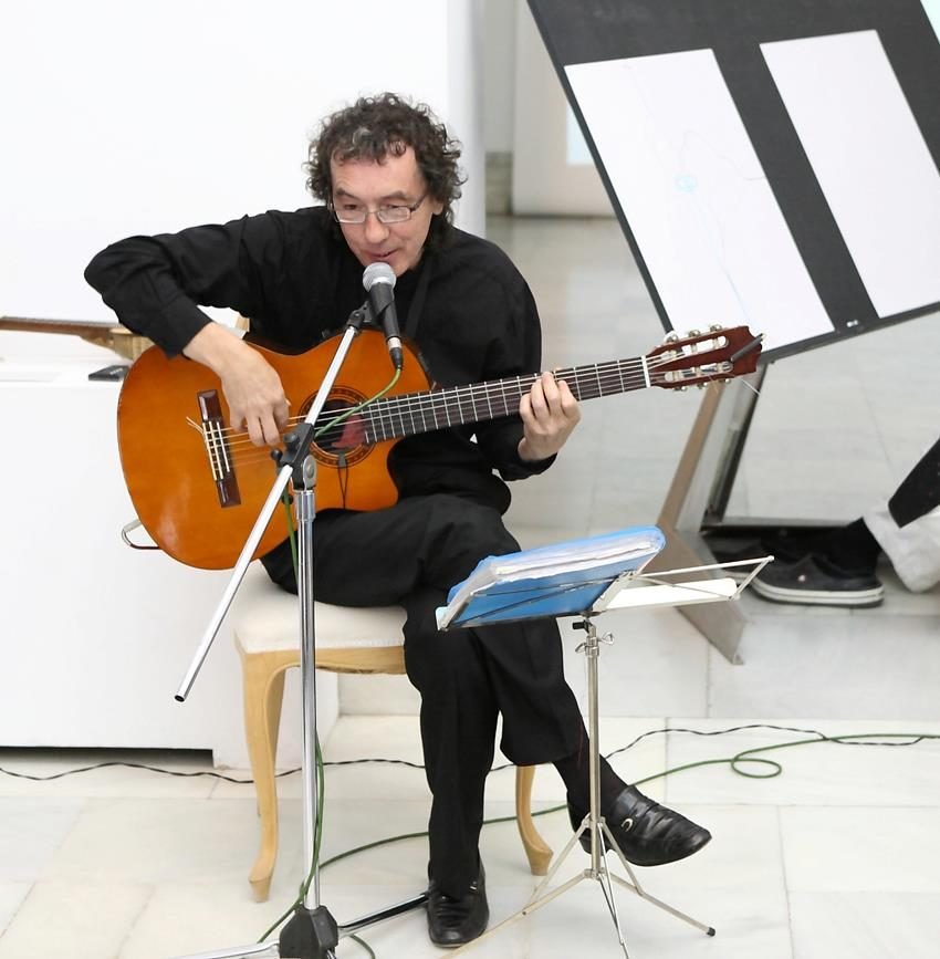 Miguel Anda cantando y tocando la guitarra en el Museo de la Ciudad de Valencia, durante la exposición de Marco Caparrón